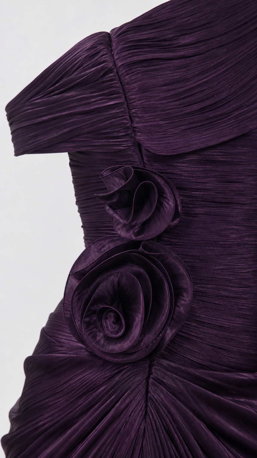 Close-up detail of pleated texture and 3D floral rosette applique on the Plum Purple gown