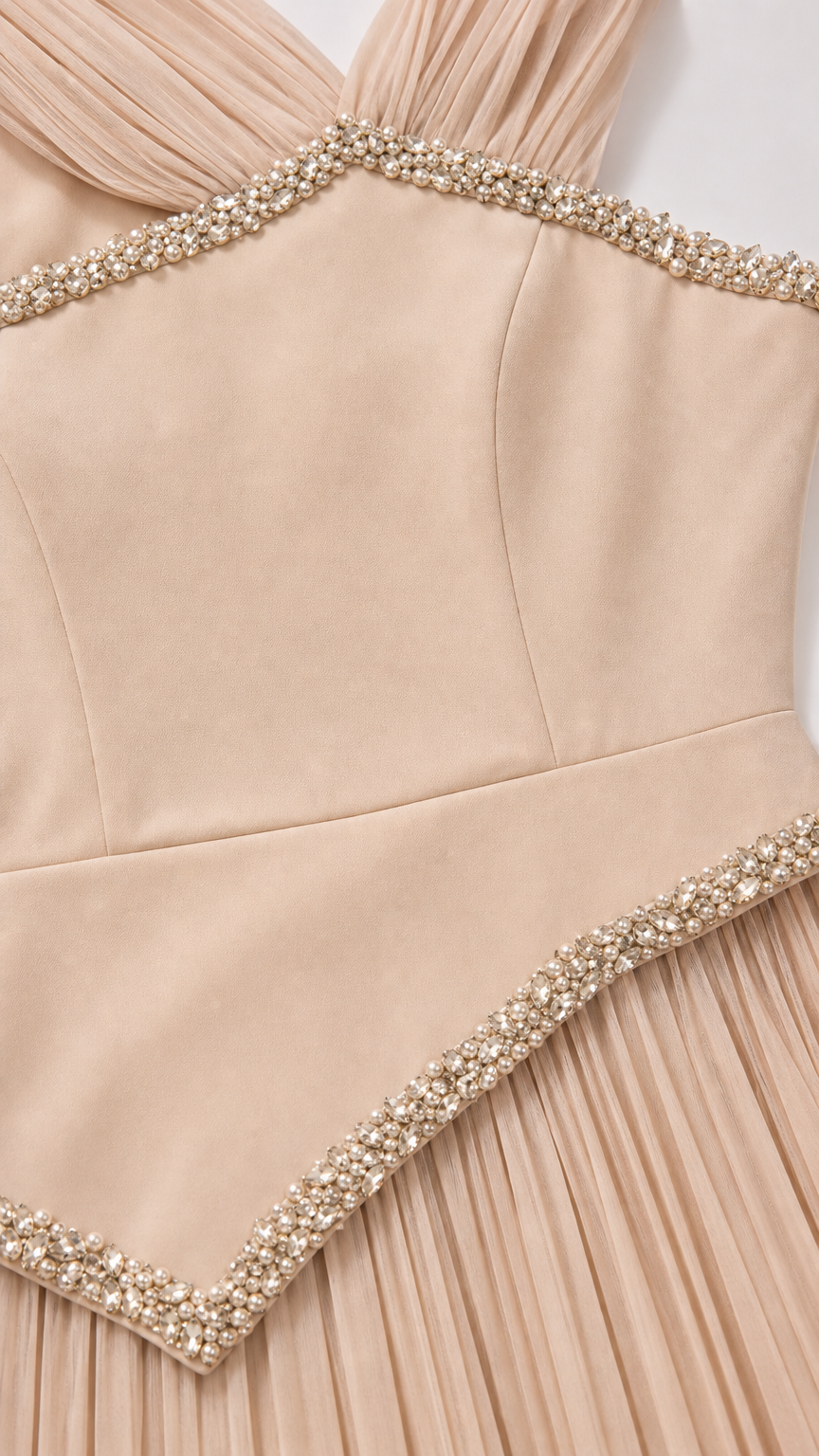 Close-up detail of rhinestone and pearl beaded trim on bodice and pleated skirt