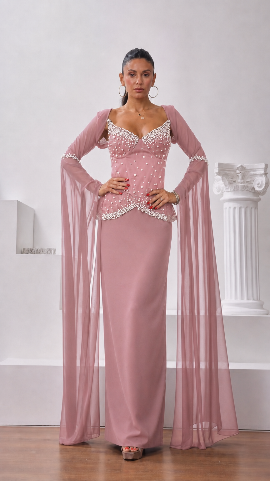 Front view of model wearing dusty pink pearl-embellished maxi gown with sheer wing sleeves