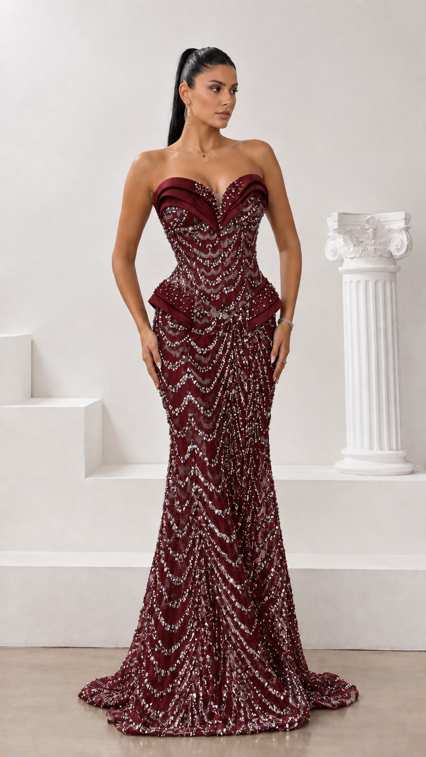 Front view of burgundy strapless beaded mermaid evening gown with sculpted fit and train