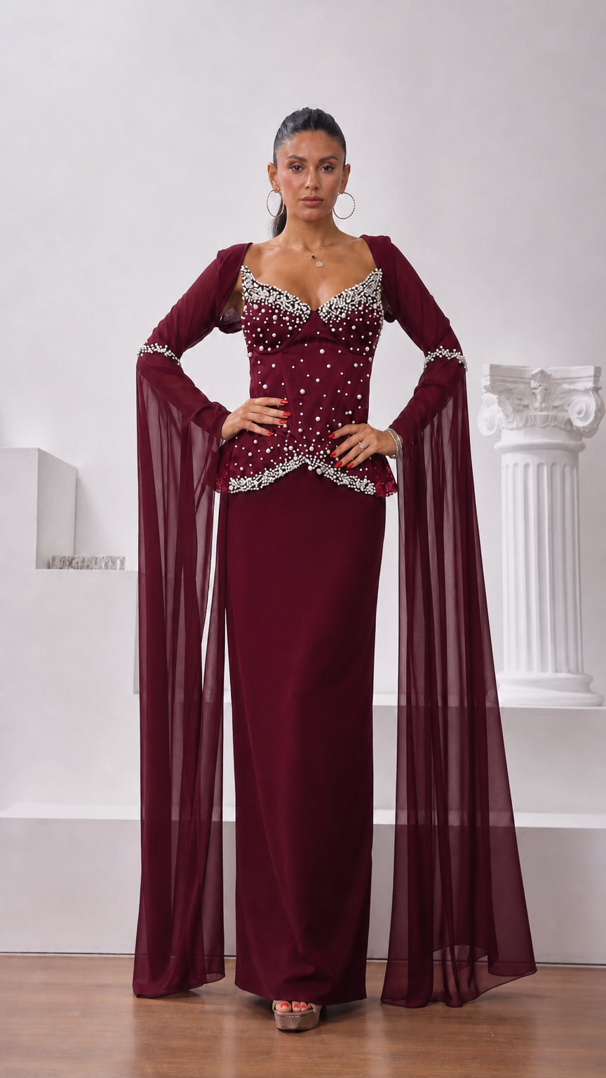 Front view of model wearing burgundy wine red pearl-detailed formal evening dress with cape sleeves