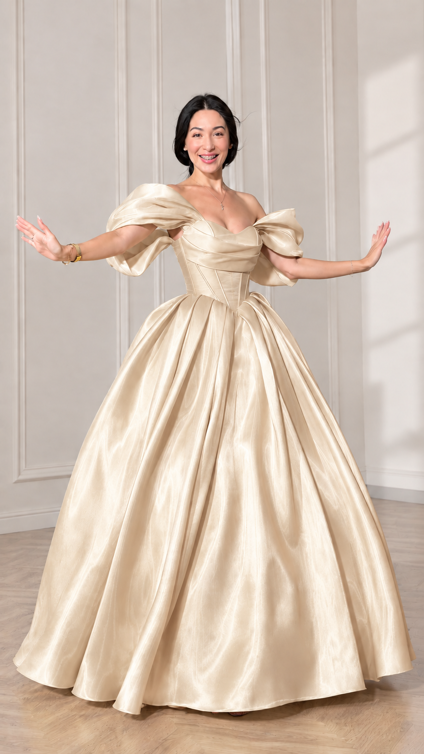 Front view of model wearing a champagne gold off-shoulder puff sleeve corset ball gown