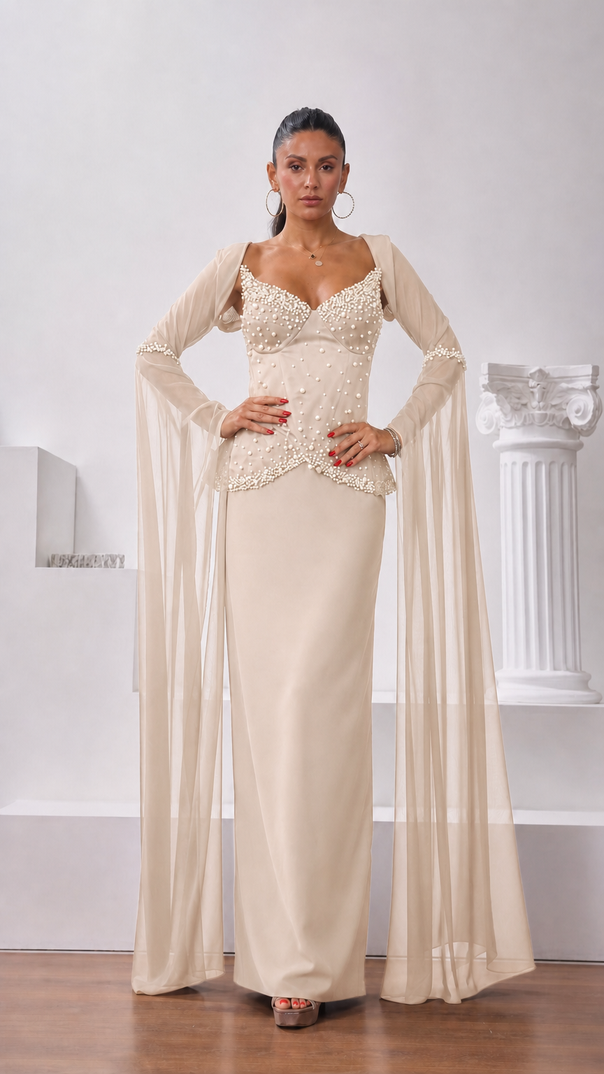 Front view of model wearing champagne cream pearl-embellished corset maxi dress with flowing sleeves