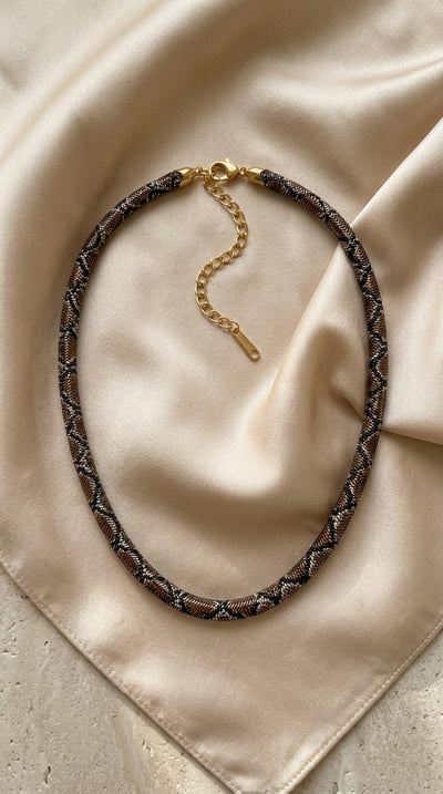Bronze necklace on cream fabric
