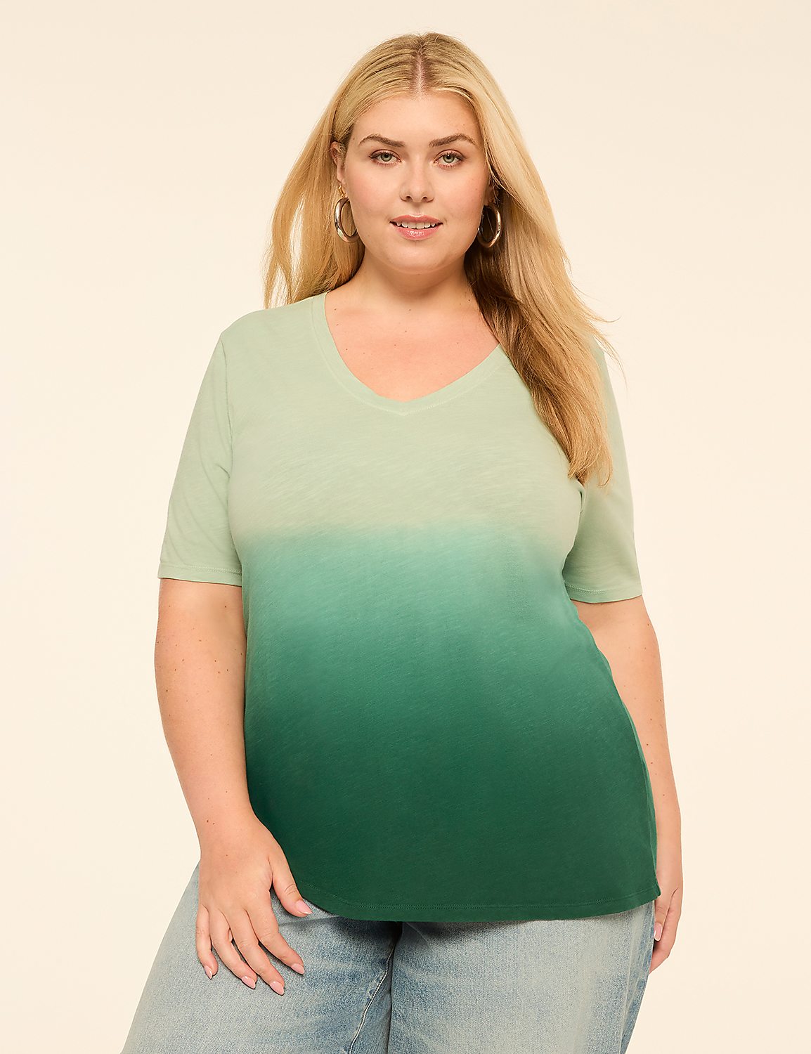 A woman in a light green to dark green ombre t-shirt and jeans stands against a plain, light-colored background. Product Image 1