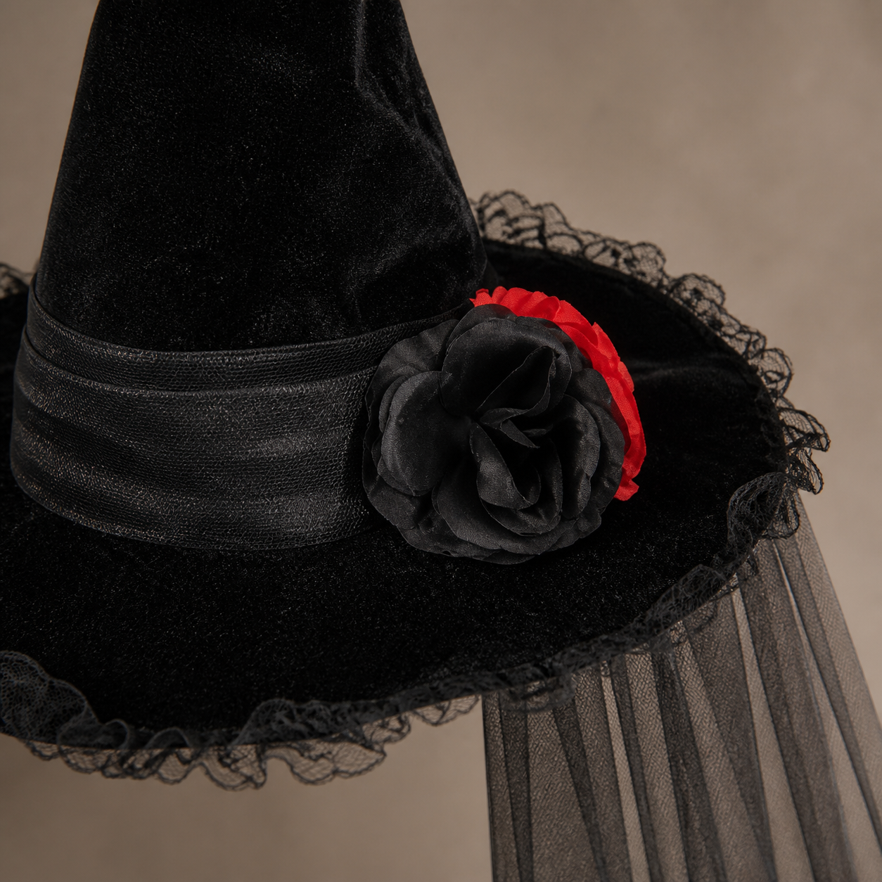 Close detail of the black rose, red accent and sheer veil attachment