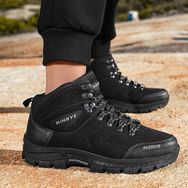 Black high-top boots on foot viewed from the side