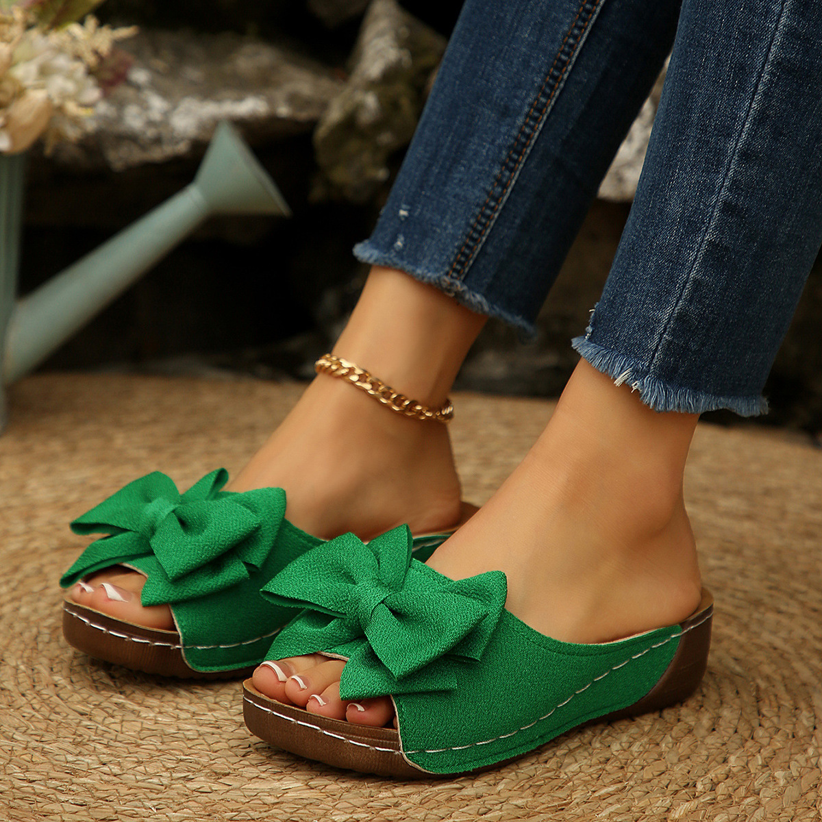 Bow-detail open-toe wedge slide sandals shown on feet