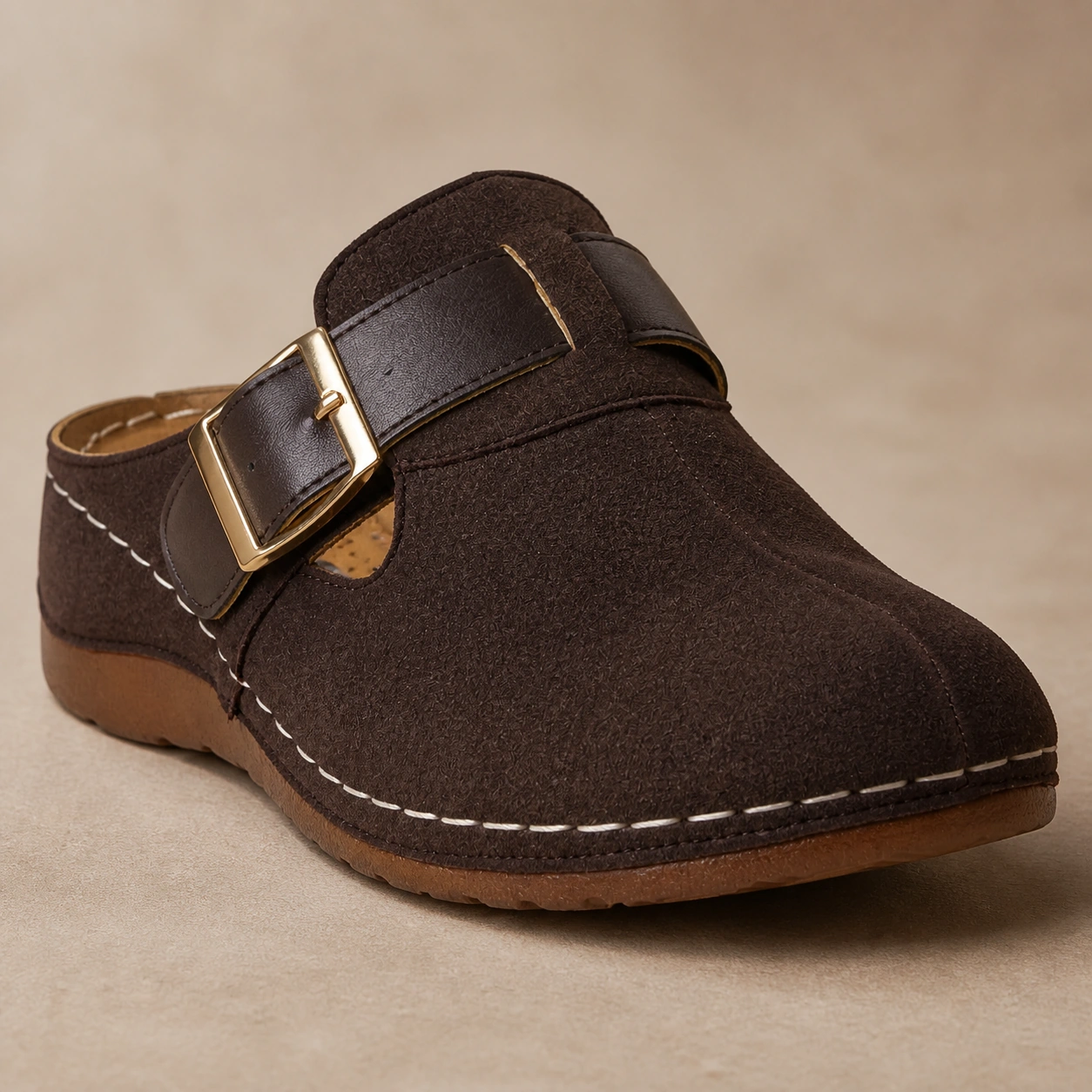 Close-up of the oversized gold-tone buckle and contrast stitching on Pippin brown clogs