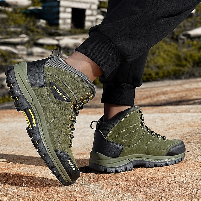 Green boots on foot showing side and tread details