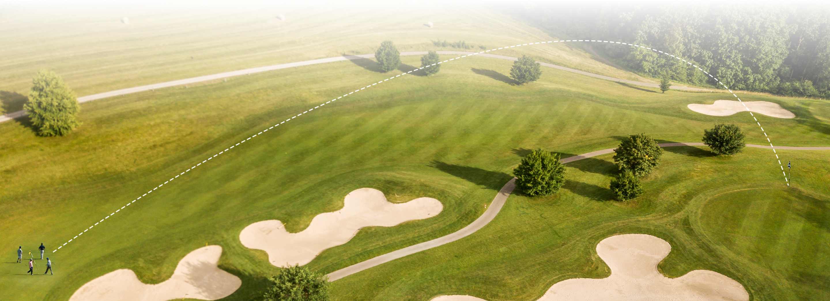 The golf course displaying ball‑flight trajectory overlays over fairways, sand traps and putting greens