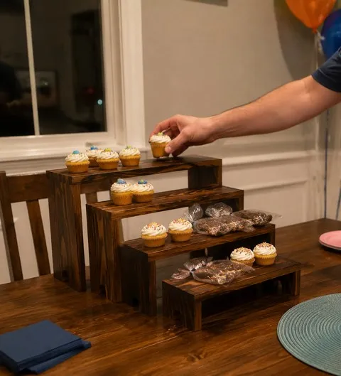 Four wood risers holding cupcakes on a family birthday table