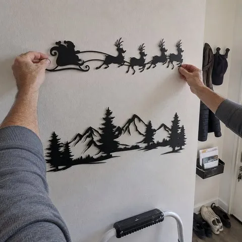 Homeowner aligning the Santa sleigh panel above the mountain scene