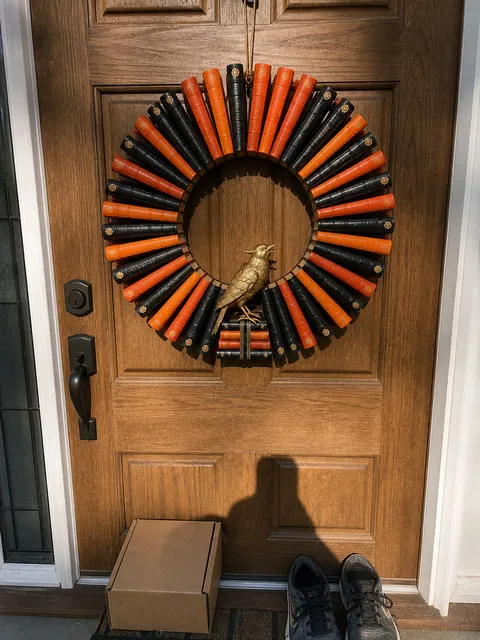 Amber Bird book wreath on a sunlit wood front door