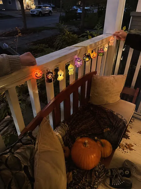 Halloween lights displayed along a covered porch railing