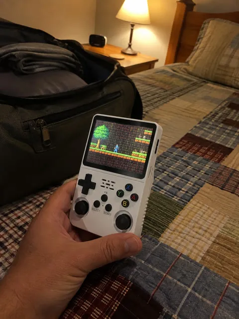 Handheld console beside a weekend travel bag