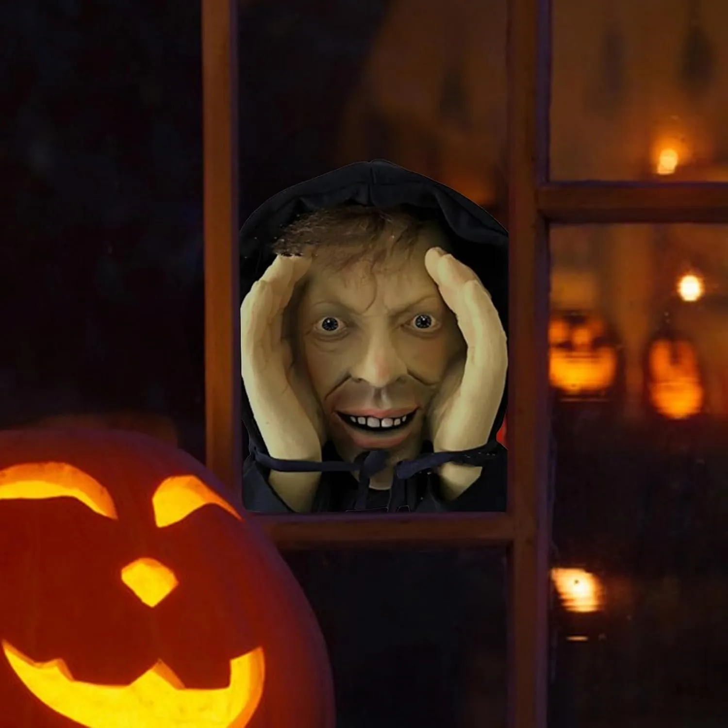 Window peeper prop framed by a glowing Halloween pumpkin