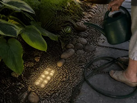 Warm glass brick light beside plants and gravel