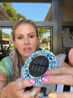 Animated view of solar mosaic ground stake light glowing in a garden at night