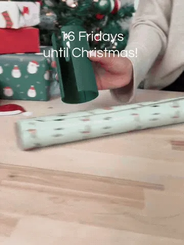 Wrapping paper passing through the cutter's long front opening as the cutter glides across the roll