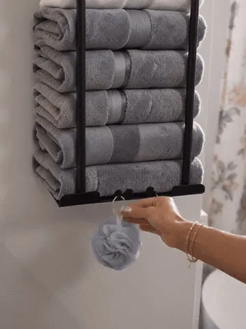 Wall-mounted towel rack being installed and filled with towels