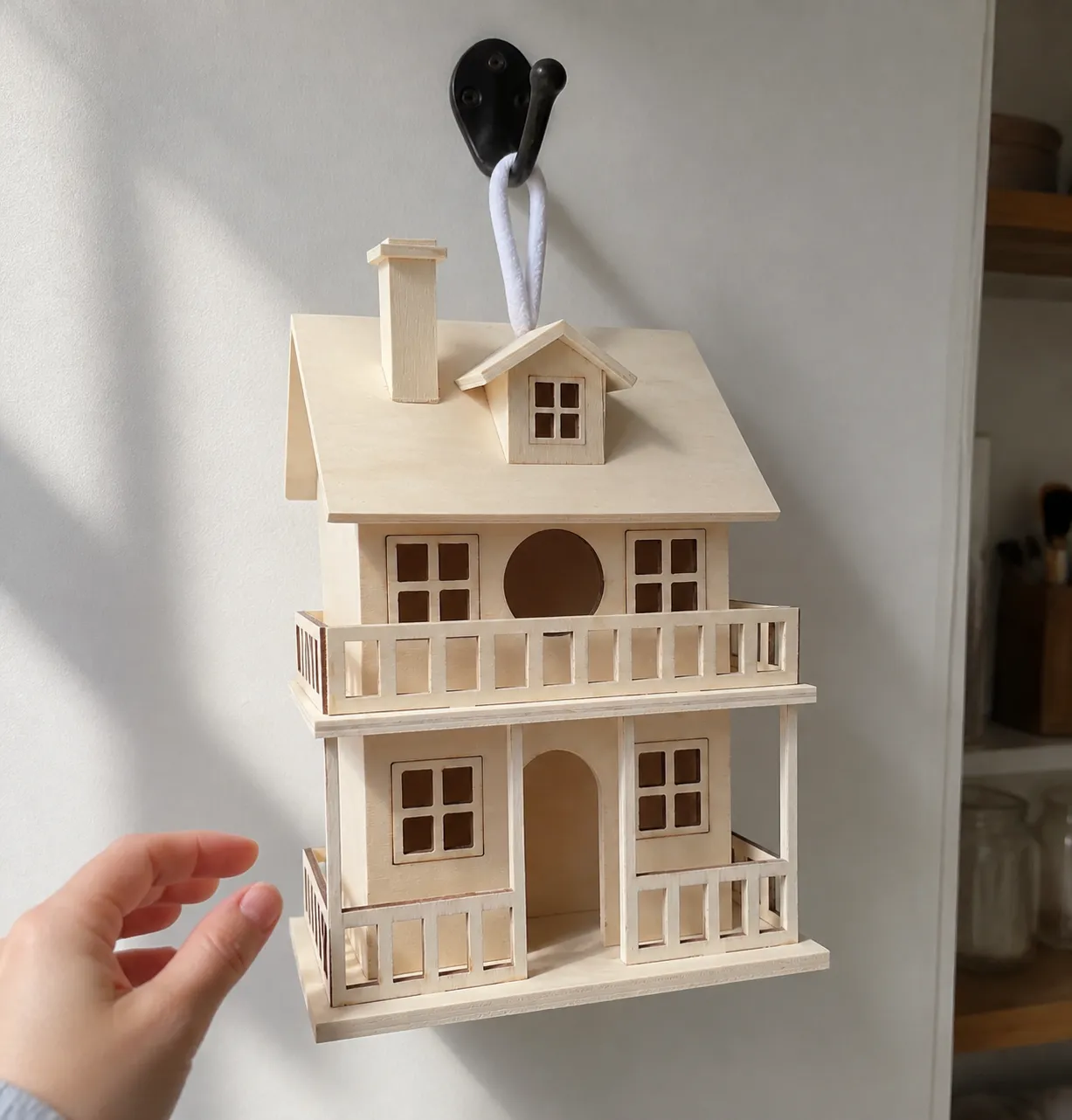Unfinished birdhouse hanging indoors