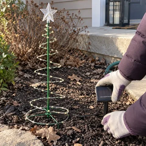 A homeowner placing the solar panel stake in a garden bed
