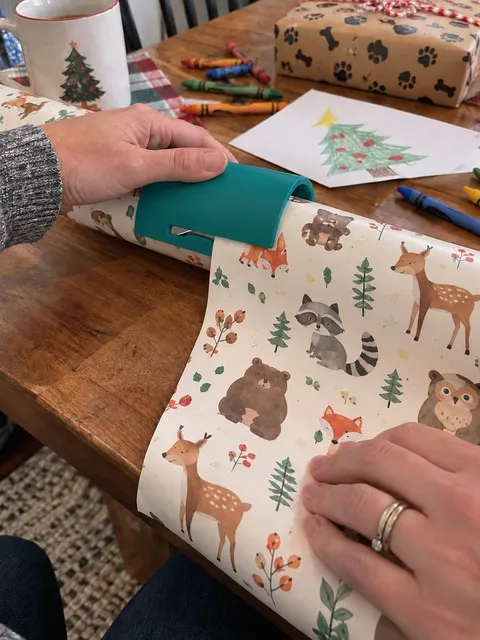 Teal wrapping paper cutter used during a family craft session
