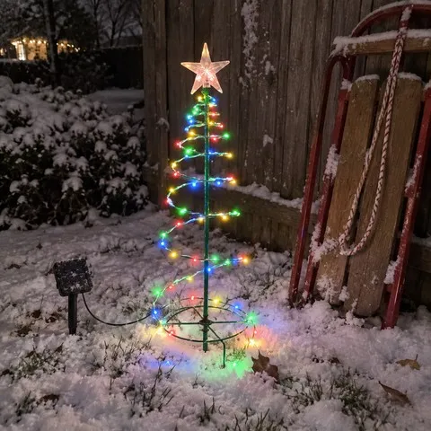 Multicolor spiral tree light beside a sled in a snowy backyard