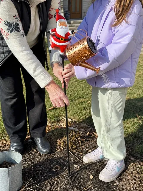 Family setting up the Santa solar garden stake