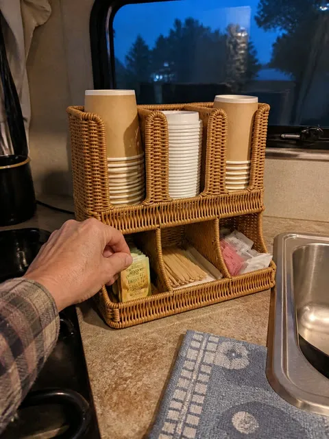 Woven cup and condiment organizer in a compact RV kitchenette