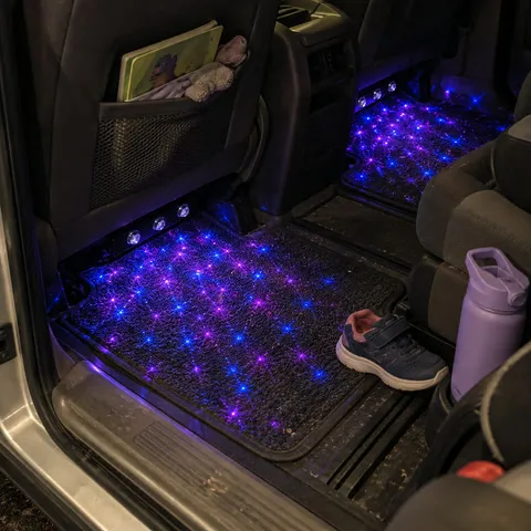 Blue and purple star lighting in a family minivan rear footwell