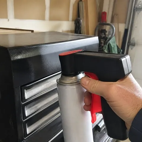 A garage DIYer using the spray-can trigger handle on a metal toolbox
