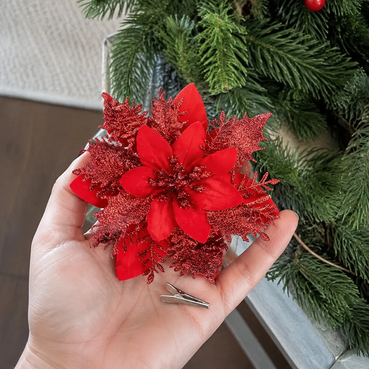 Hand showing the poinsettia decoration clip