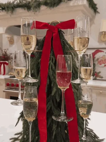 Cocktail glass tree being styled as a festive centerpiece and loaded with drinks