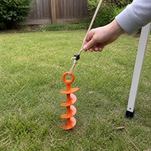 Canopy guyline attached to an orange ground anchor