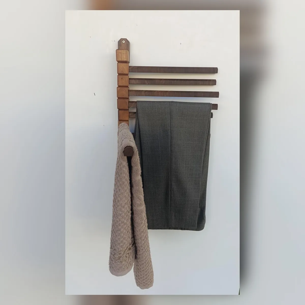 Wooden rack holding pants and a scarf