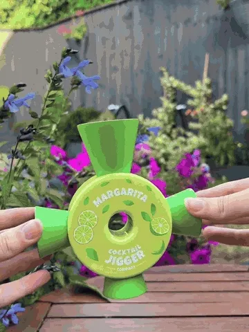 Four-way cocktail jigger measuring margarita ingredients into a shaker