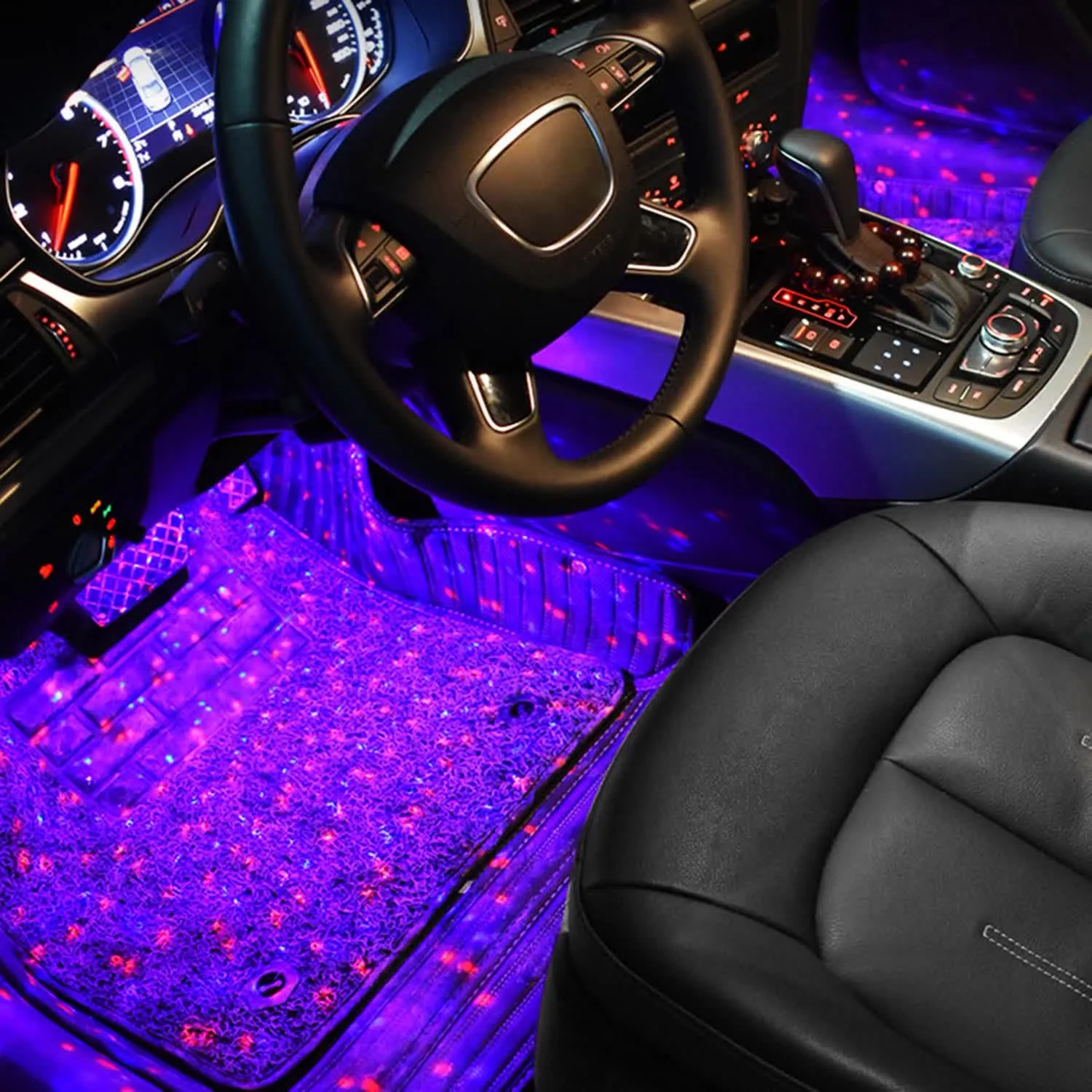 Purple and red star lighting across a car footwell