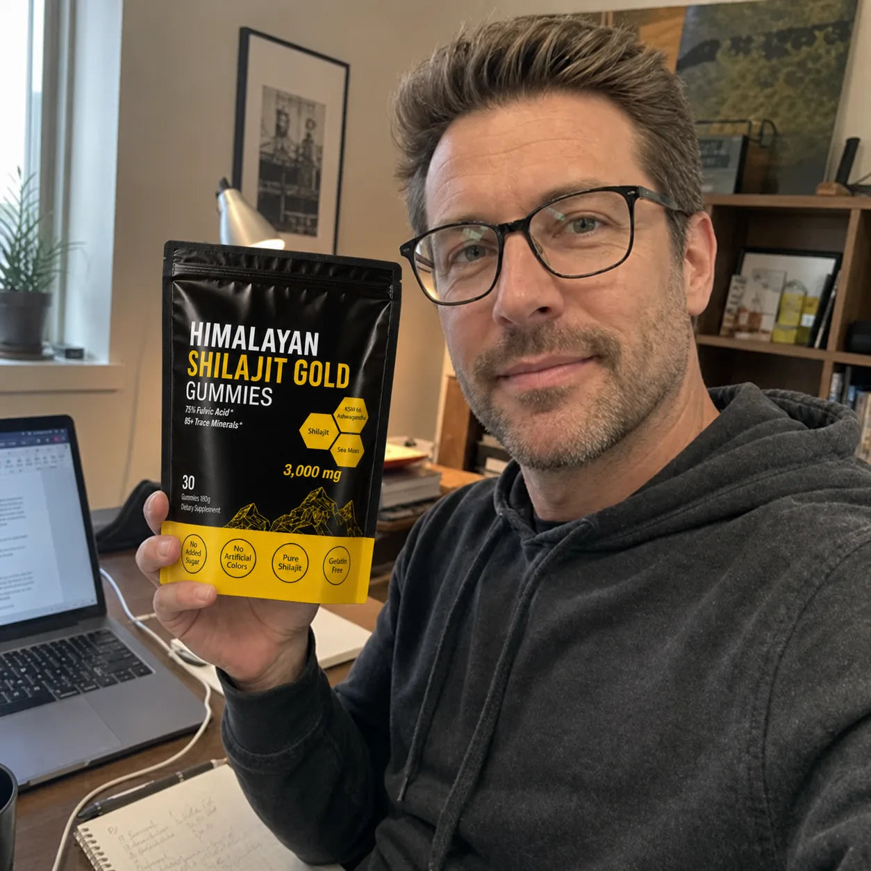 Customer holding MENRYX gummies in a home office