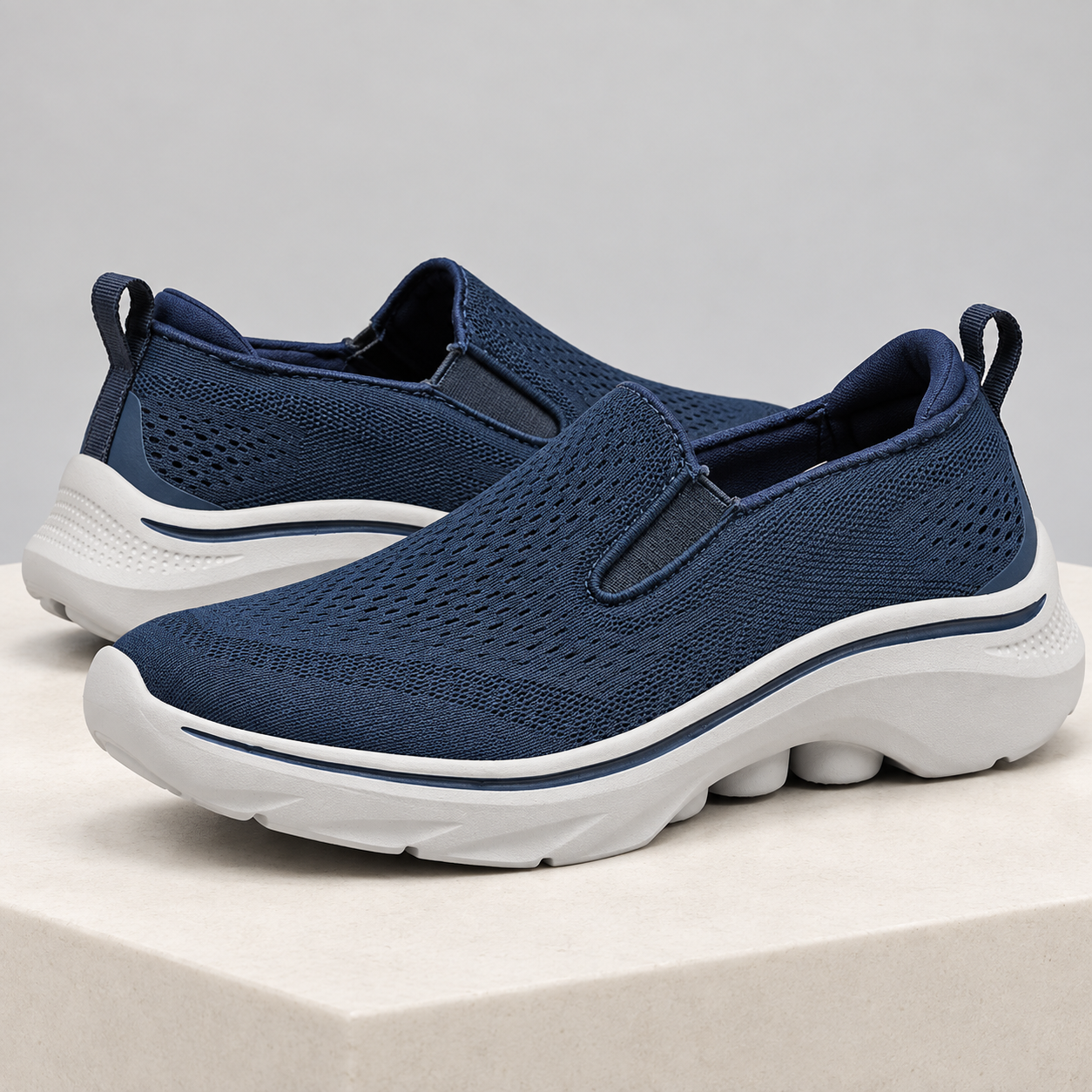 Navy Motion mesh slip-on sneakers with elastic side gores and sculpted white soles.