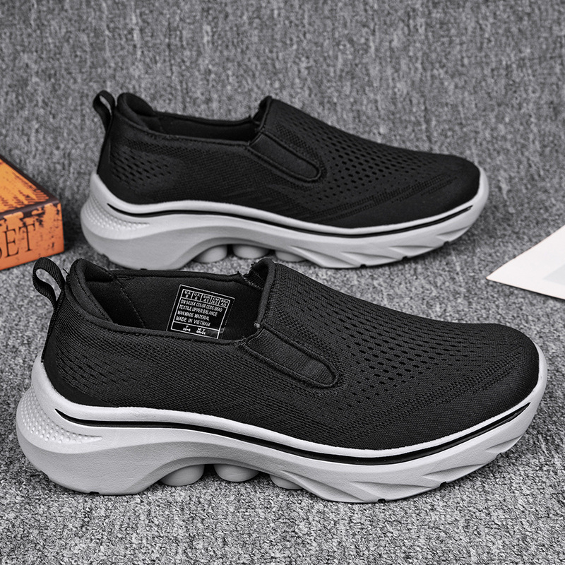 Black Motion mesh slip-on sneakers with sculpted white soles.