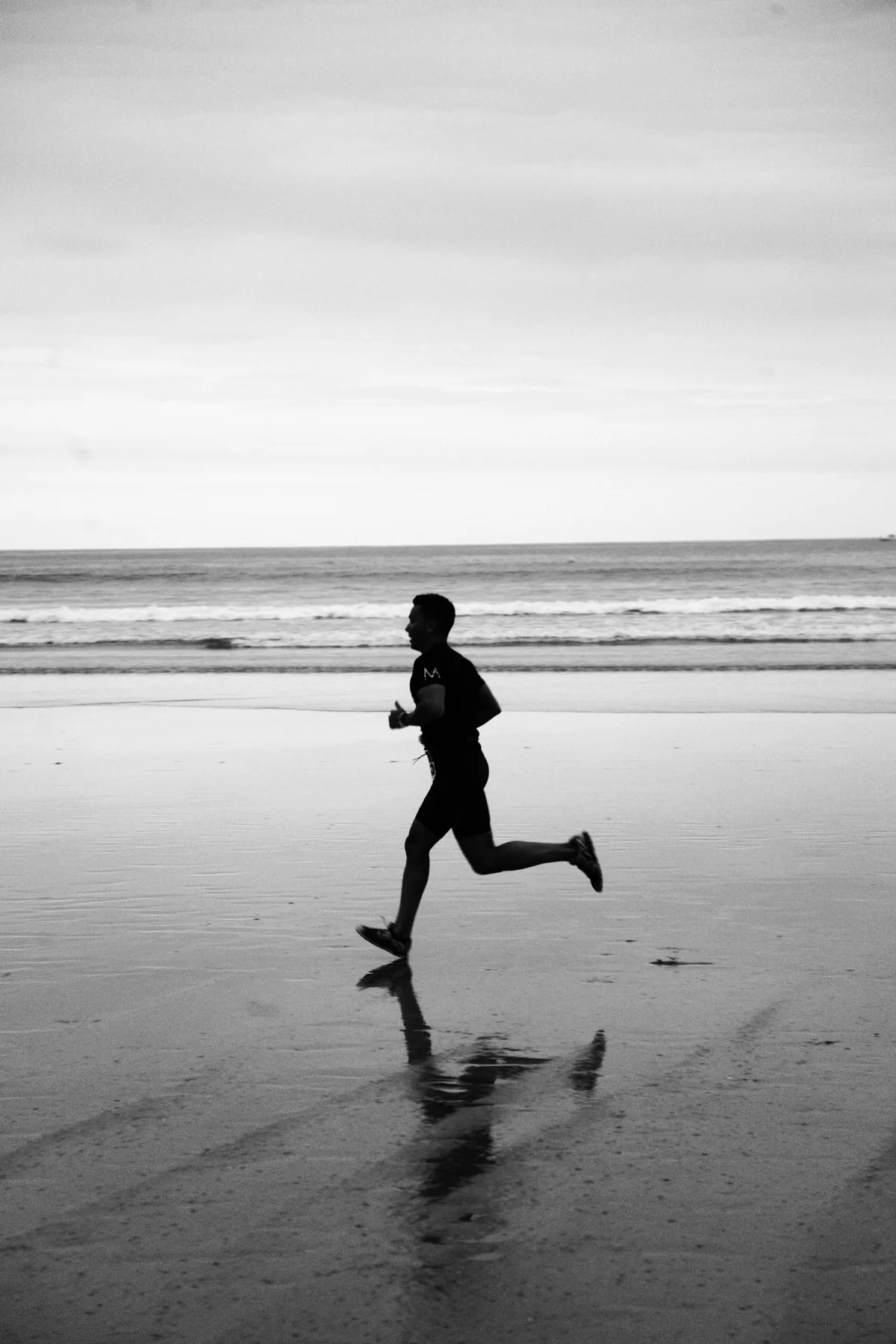 A runner at first light, mid-stride on an empty road