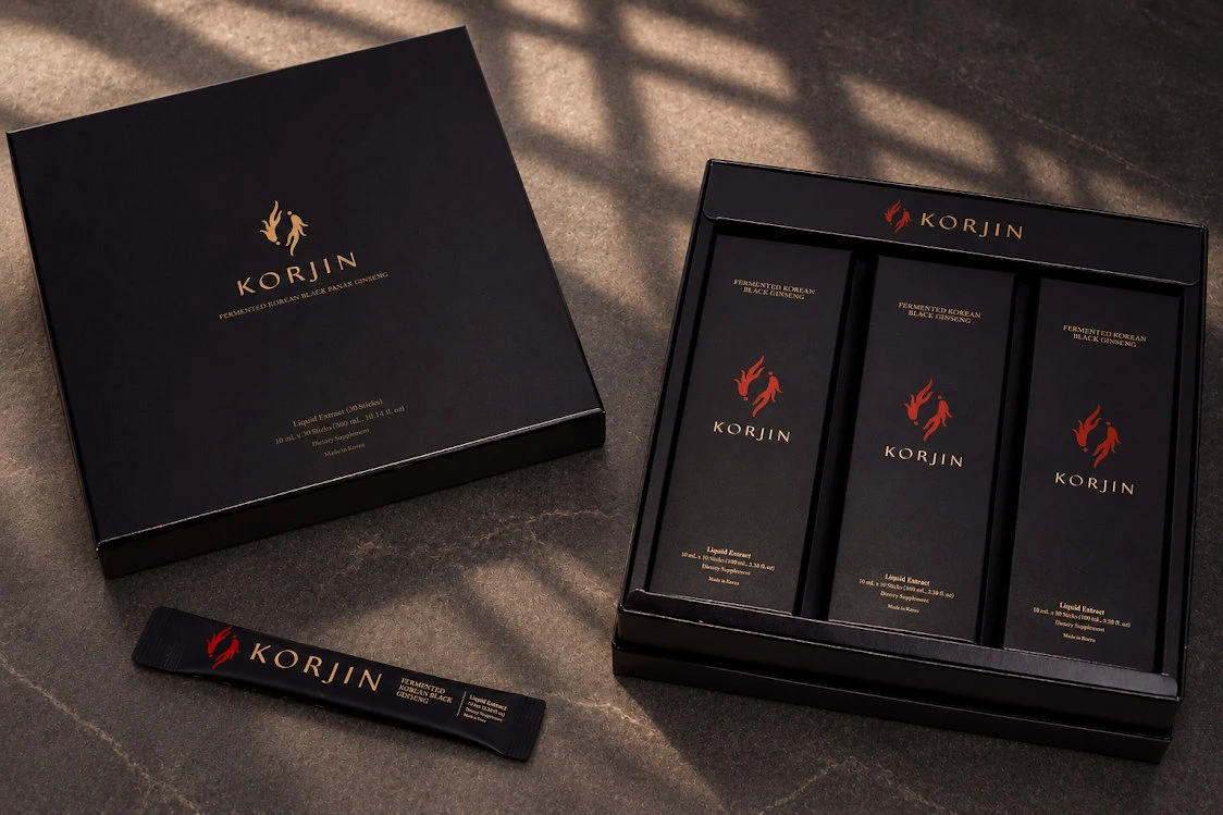 A Korjin 30-pack in window light: the closed lid beside the open tray of three 10-stick boxes, and a stick