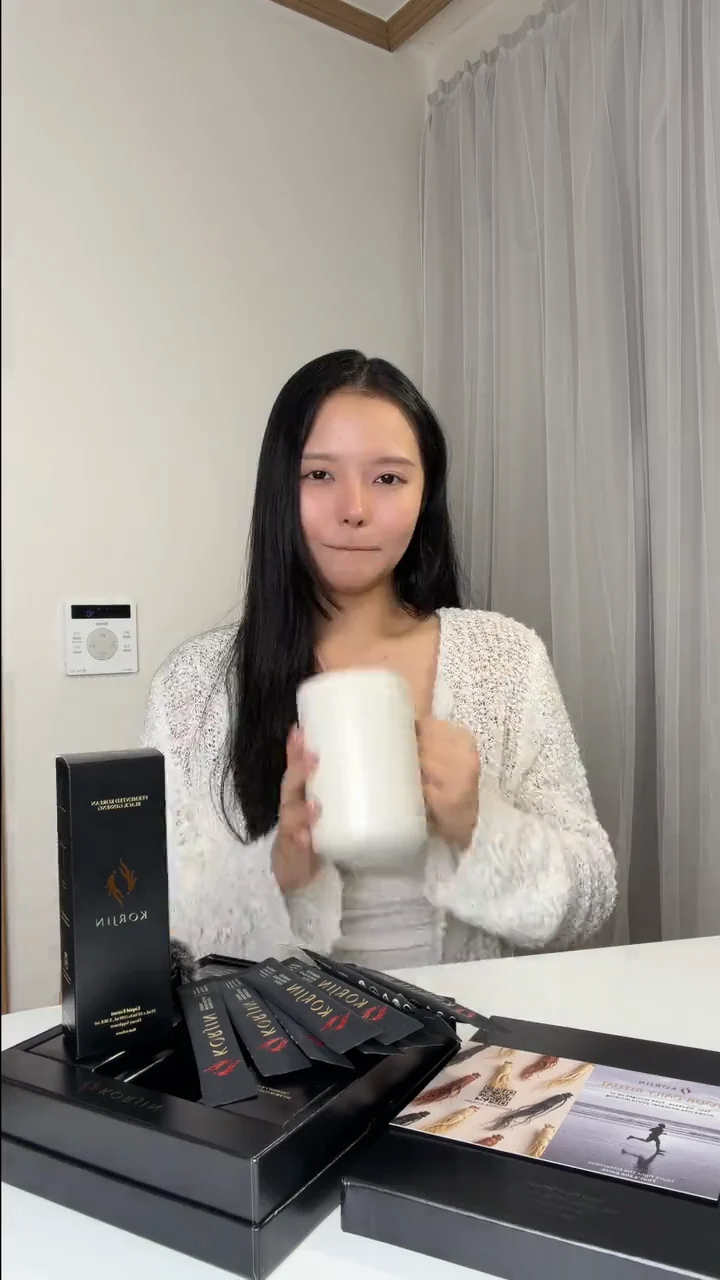 Audrey at a table with a mug, a box of Korjin sticks in front of her