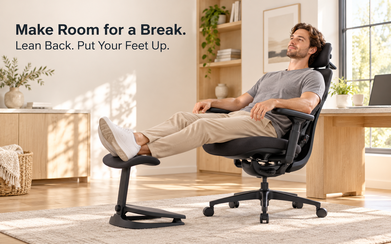 User reclining in the black ergonomic chair with legs resting on the matching independent footrest