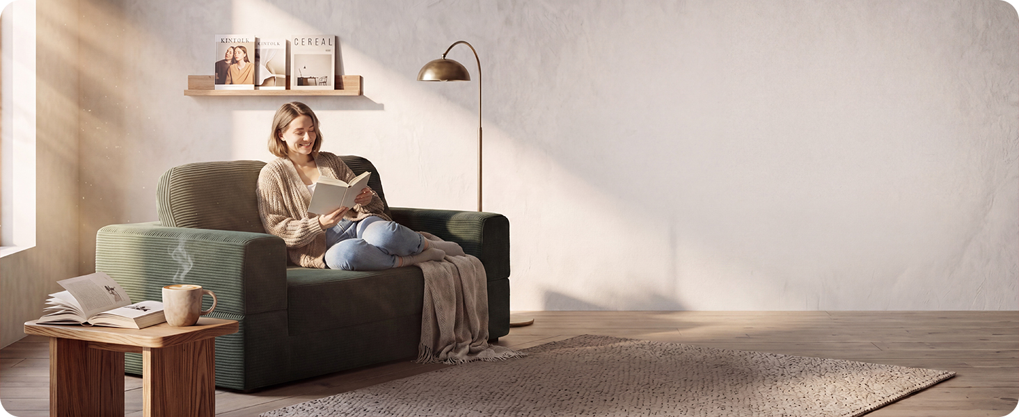 Fully expanded green corduroy floor sofa styled with pillows in a cozy private reading nook.