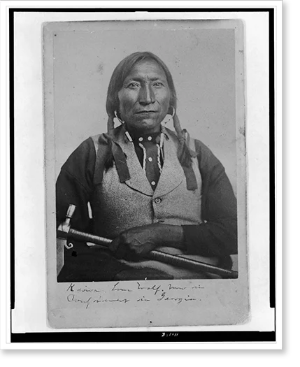 Historic Framed Print, [Lone Wolf, a Kiowa chief, half-length portrait, seated, facing front, holding tomahawk], 17-7/8" x 21-7/8"