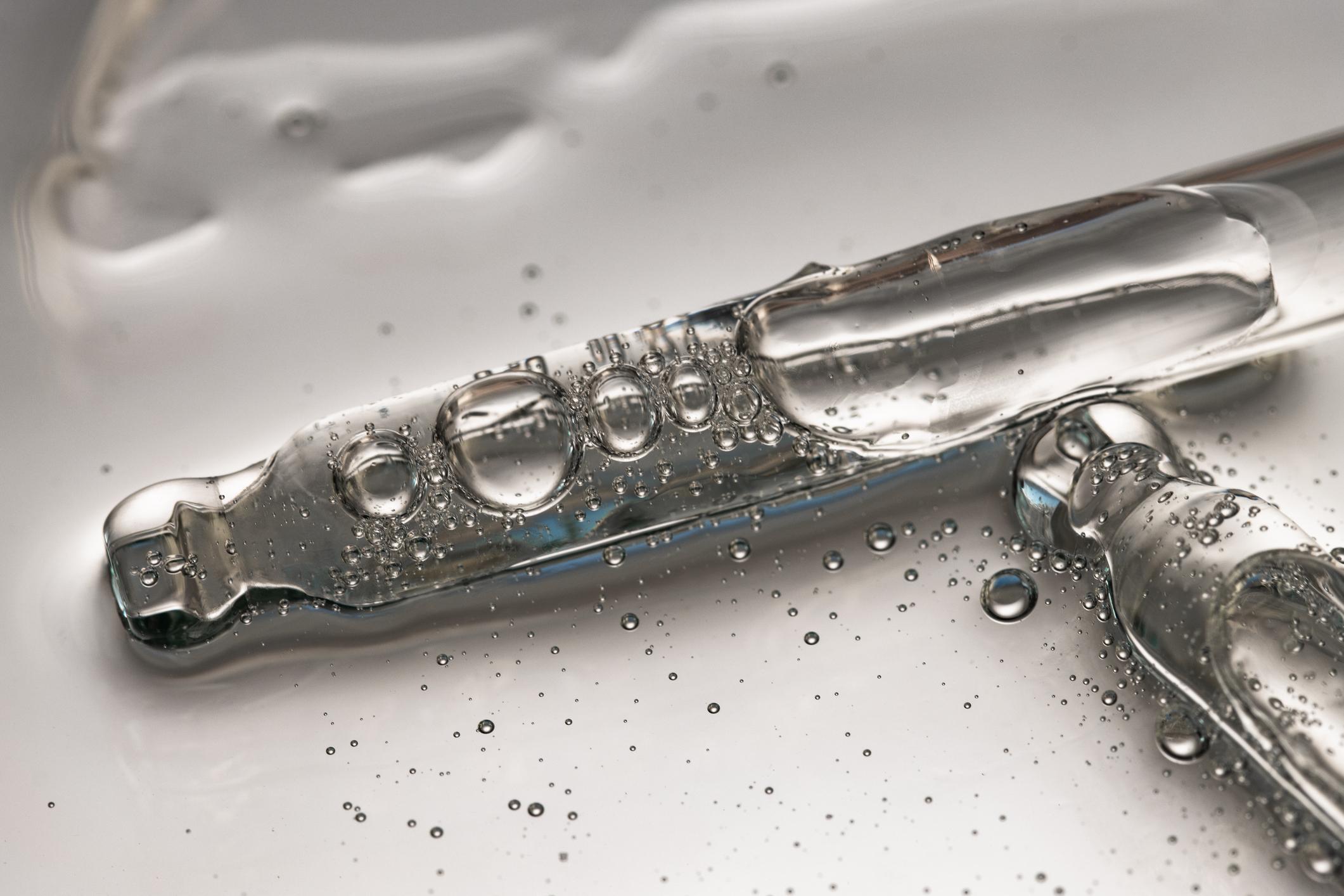 Droppers with liquid texture for moisturizing and skin care, cosmetic background macro.