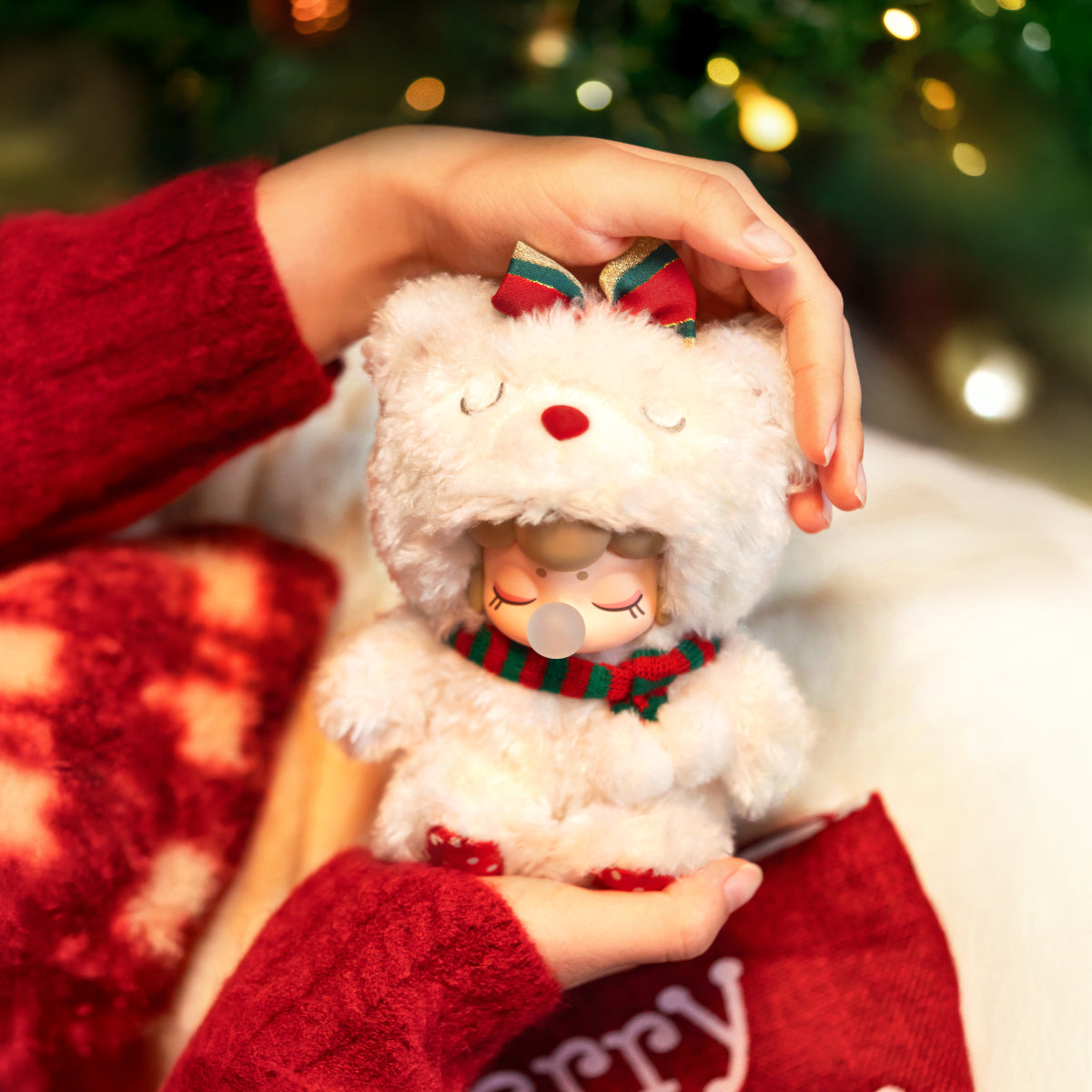 Pendentif en peluche Nanci Christmas Bear tenu à la main dans une scène festive